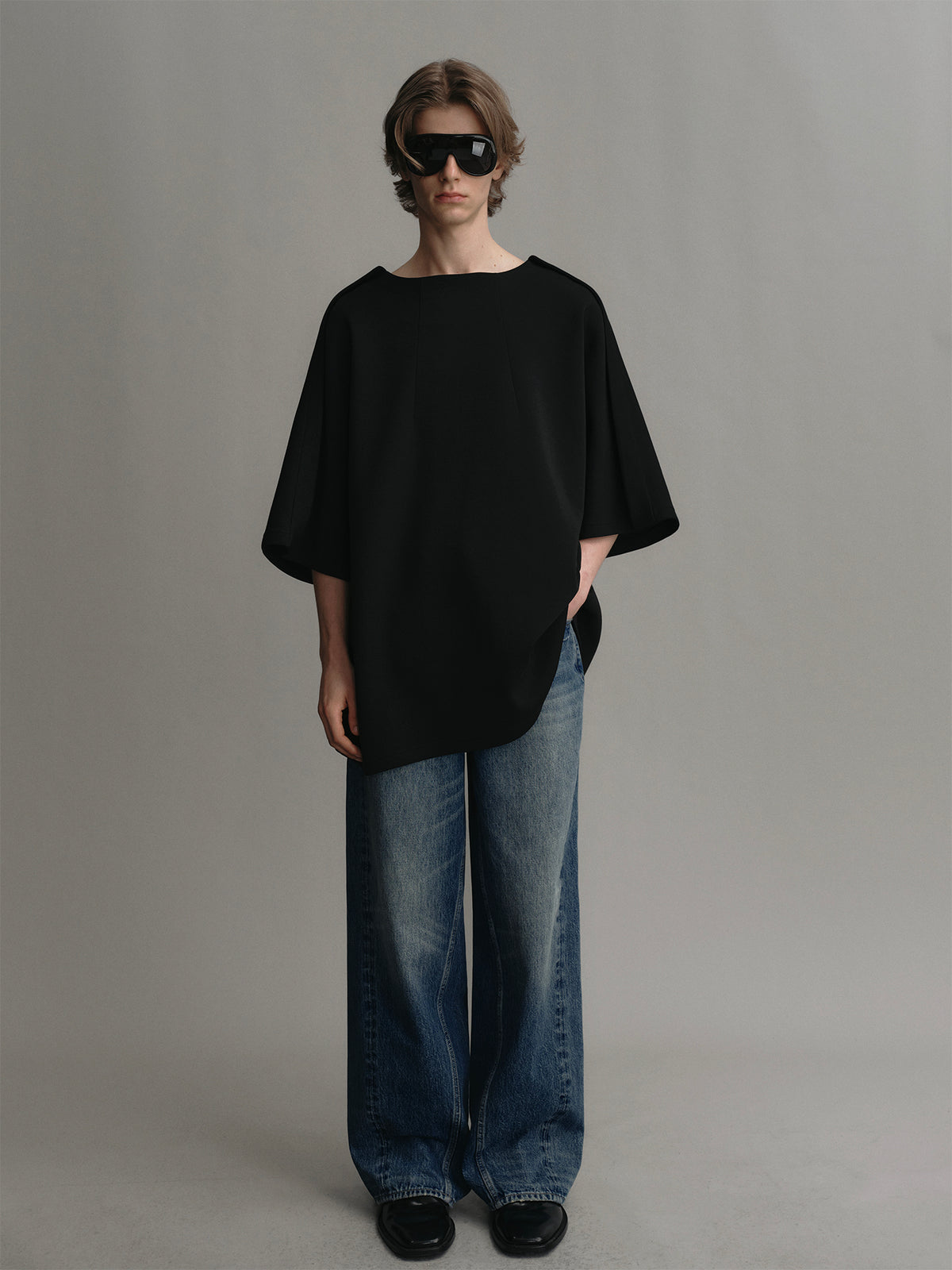 Black t shirt with a trapezoidal collar design and an airy silhouette